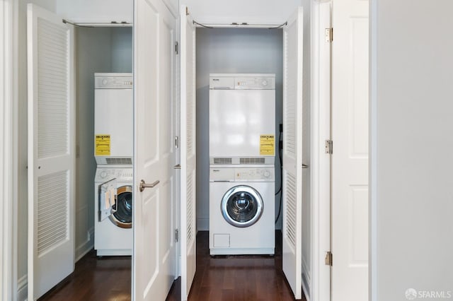 laundry area featuring stacked washer / dryer and dark hardwood / wood-style floors