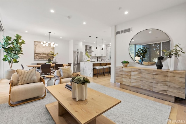 living room featuring an inviting chandelier and light hardwood / wood-style floors