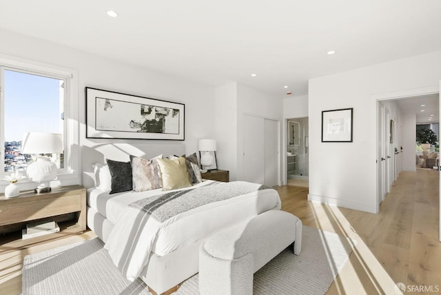 bedroom featuring light wood-type flooring and ensuite bathroom