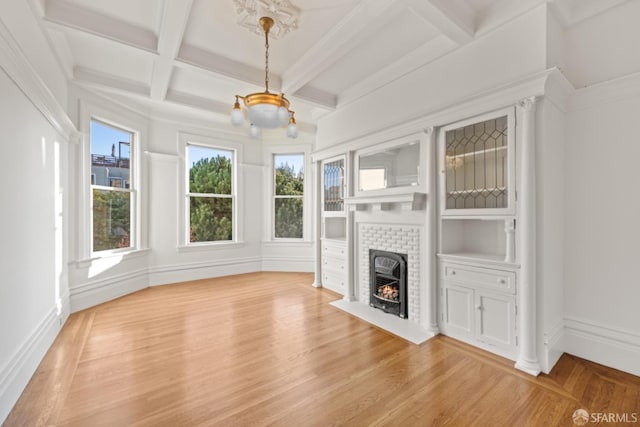 unfurnished living room featuring coffered ceiling, beamed ceiling, a fireplace, and light wood-type flooring