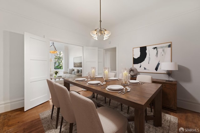 dining room with dark hardwood / wood-style floors and a chandelier