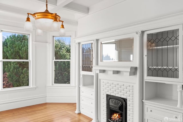 living room featuring beam ceiling, a brick fireplace, coffered ceiling, and light wood-type flooring