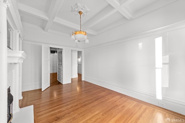 unfurnished bedroom featuring coffered ceiling, hardwood / wood-style floors, and beam ceiling