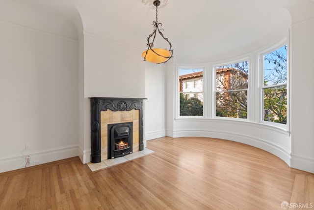 unfurnished living room with plenty of natural light, hardwood / wood-style floors, and a tile fireplace