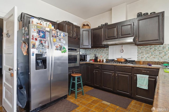 kitchen featuring backsplash, dark brown cabinets, and stainless steel appliances