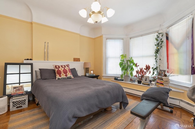 bedroom with ceiling fan with notable chandelier and a baseboard radiator