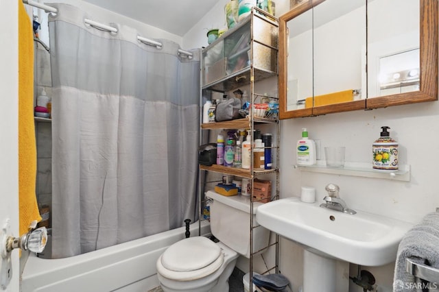 full bathroom featuring sink, shower / bath combo with shower curtain, and toilet