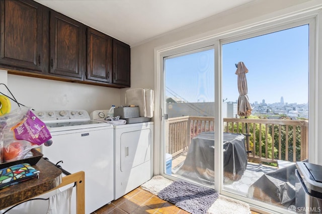 laundry area featuring washer and clothes dryer, tile patterned flooring, cabinets, and plenty of natural light