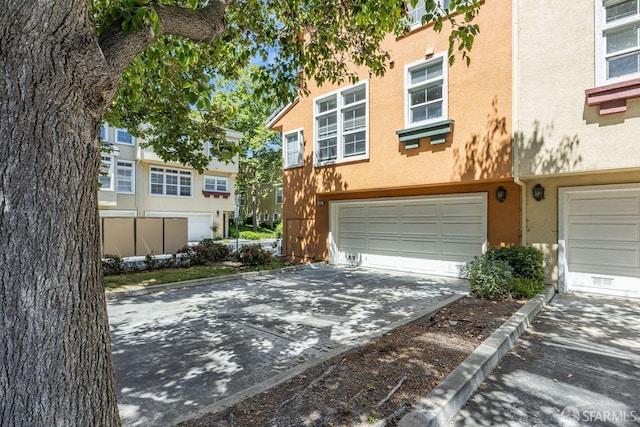 3587 Fitzsimmons Cmn, Fremont, CA 94538 - view of front of home with a garage, stucco siding, and driveway