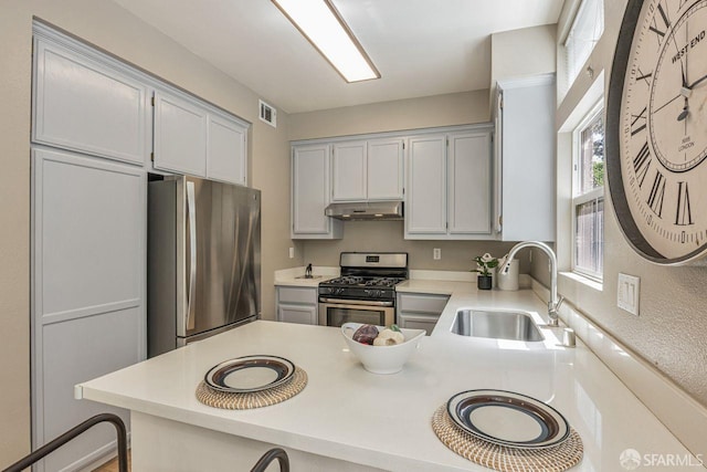 3587 Fitzsimmons Cmn, Fremont, CA 94538 - kitchen featuring appliances with stainless steel finishes, under cabinet range hood, a peninsula, light countertops, and a kitchen bar