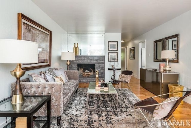 living room featuring a fireplace and baseboards