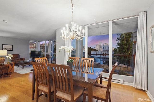 dining space with expansive windows, a chandelier, and light hardwood / wood-style floors