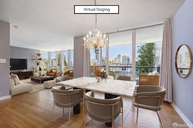 dining space with plenty of natural light, light wood-type flooring, and a wall of windows