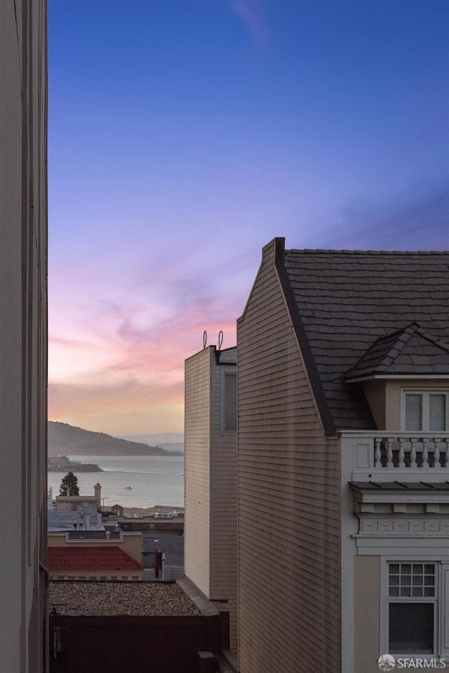 property exterior at dusk with a water view