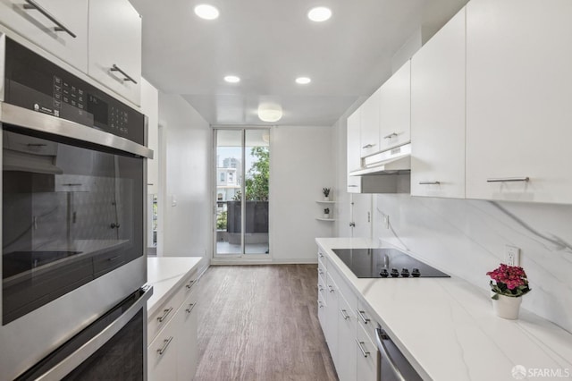 kitchen featuring white cabinetry, stainless steel appliances, light hardwood / wood-style floors, and light stone counters