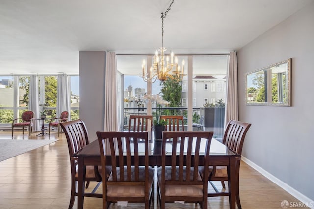 dining room with expansive windows, a notable chandelier, and light hardwood / wood-style floors