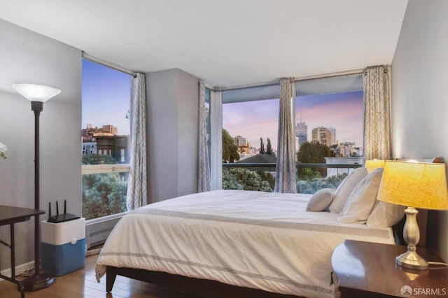 bedroom featuring a wall of windows and hardwood / wood-style floors