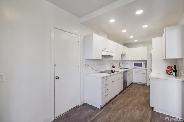 kitchen with white cabinetry, sink, dark hardwood / wood-style flooring, decorative backsplash, and white appliances