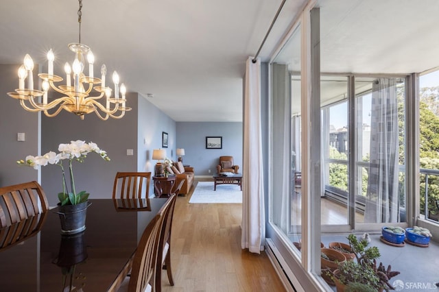 dining area featuring an inviting chandelier, floor to ceiling windows, and light wood-type flooring