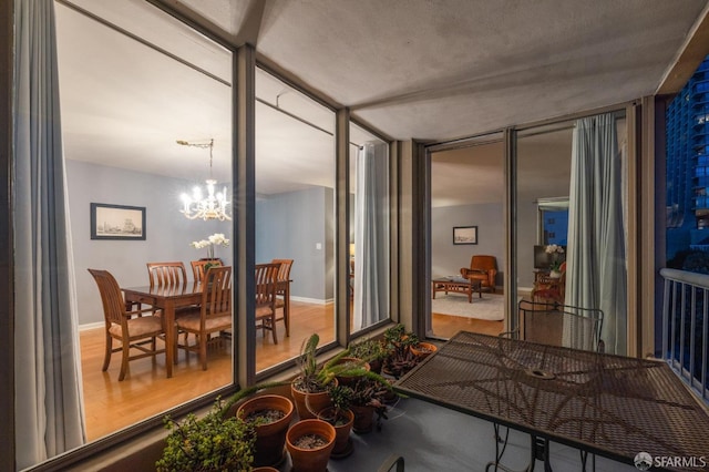 sunroom / solarium with a notable chandelier