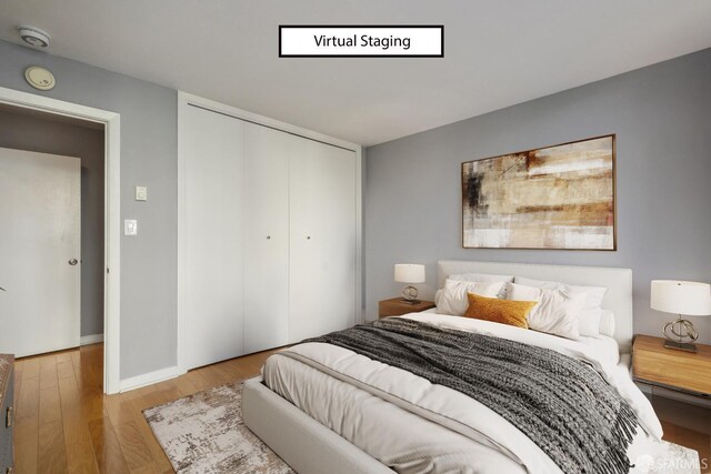 bedroom with light hardwood / wood-style floors and a closet