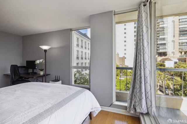 bedroom with wood-type flooring and multiple windows