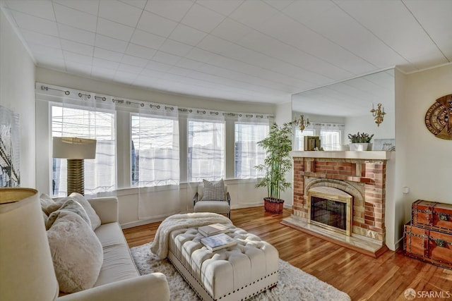 living room with a wealth of natural light, wood finished floors, and a fireplace