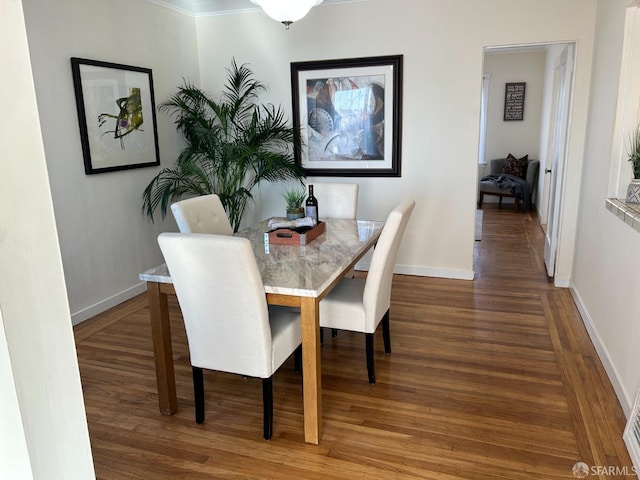 dining space with baseboards and wood finished floors