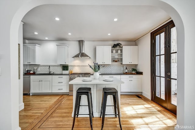 224 Twin Peaks Blvd, San Francisco, CA 94114 - kitchen featuring stainless steel appliances, wall chimney range hood, arched walkways, open shelves, and recessed lighting