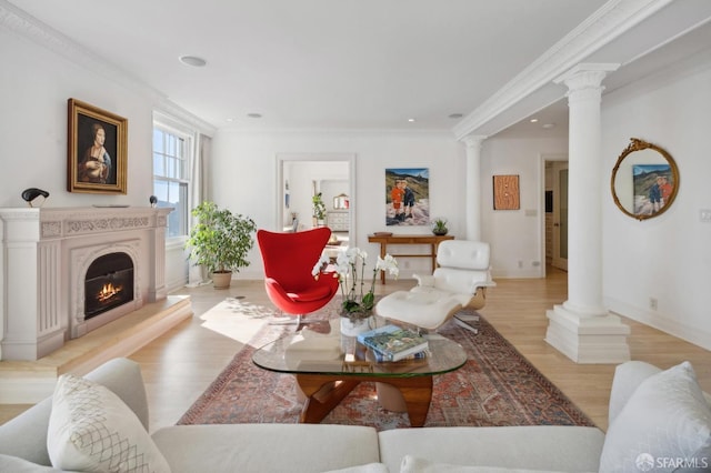 living room featuring crown molding, decorative columns, and light hardwood / wood-style flooring