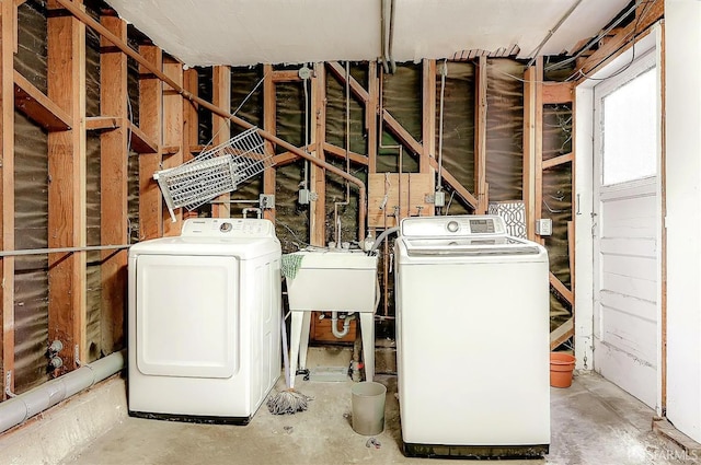 washroom with laundry area, a sink, and independent washer and dryer