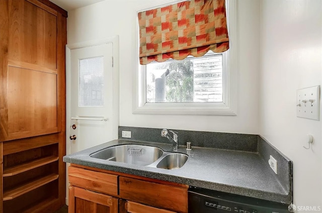 kitchen featuring dark countertops, black dishwasher, brown cabinetry, and a sink