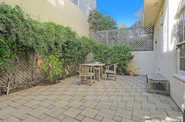 view of patio with outdoor dining area and fence