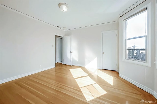 spare room with light wood finished floors and baseboards