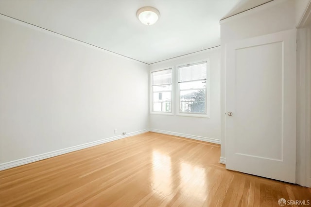 empty room with light wood-type flooring and baseboards