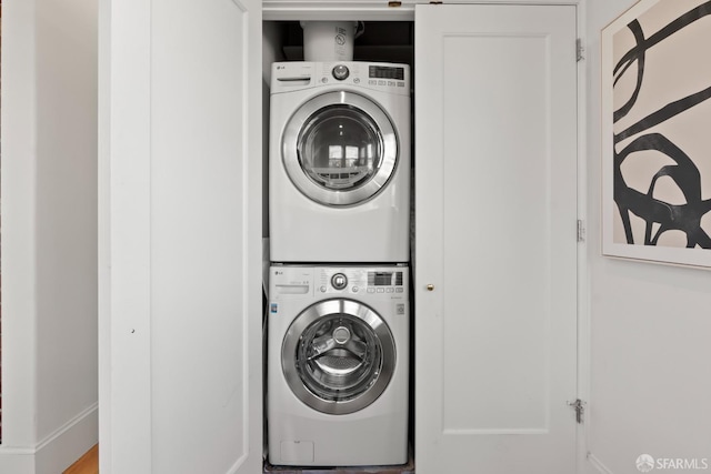 clothes washing area featuring stacked washer and dryer