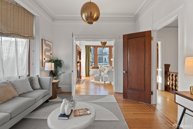 living room with ornamental molding and light wood-type flooring