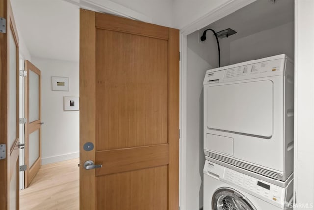 1207 Indiana St Unit 10, San Francisco, CA 94107 - laundry room featuring light wood-style flooring, baseboards, stacked washer / dryer, and laundry area