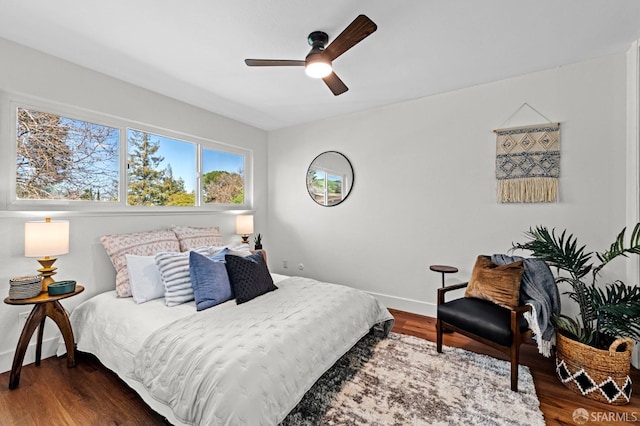 bedroom with ceiling fan and dark hardwood / wood-style flooring