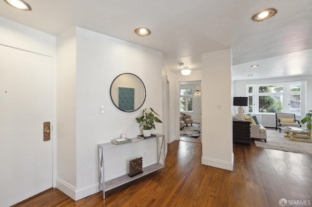 hallway with recessed lighting, wood finished floors, and a healthy amount of sunlight