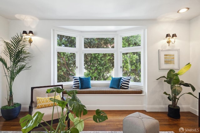 sitting room with a healthy amount of sunlight, baseboards, and wood finished floors