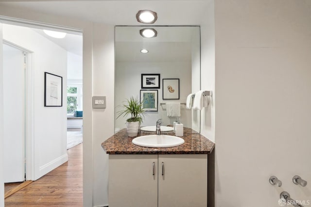 bathroom with recessed lighting, wood finished floors, and vanity