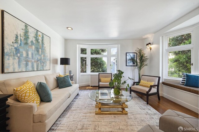 living area with recessed lighting, baseboards, and wood finished floors