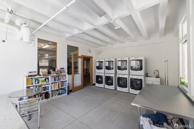 shared laundry area featuring stacked washer / dryer and a sink