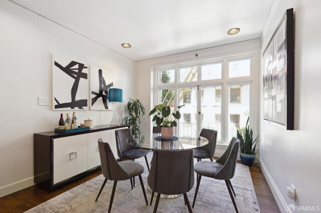 dining space featuring french doors, baseboards, crown molding, and dark wood-style flooring