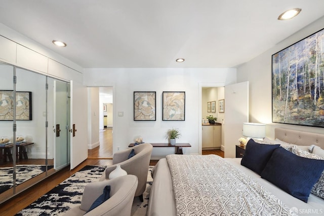 bedroom featuring baseboards, wood finished floors, and recessed lighting