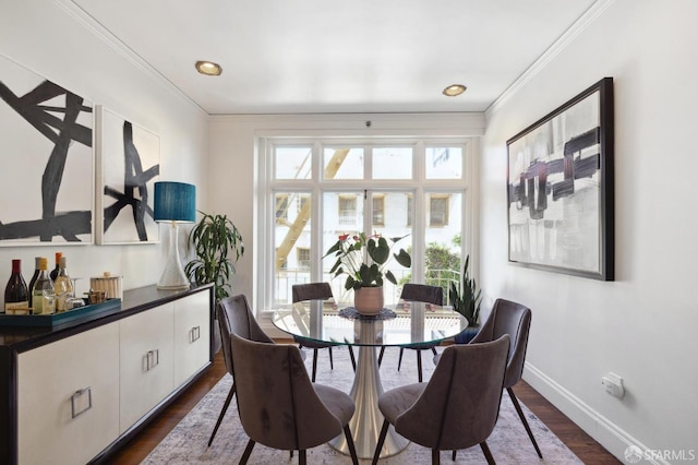 dining room with baseboards, ornamental molding, and dark wood-style flooring