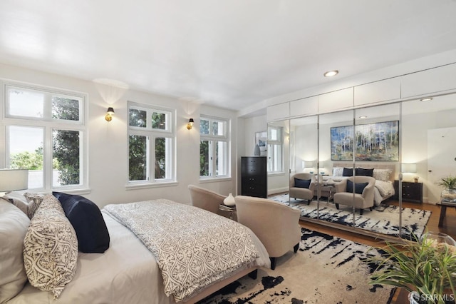 bedroom with a closet, wood finished floors, and recessed lighting