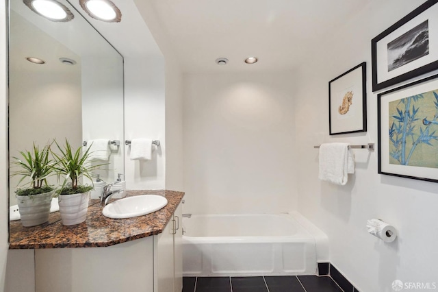 bathroom with a washtub, recessed lighting, vanity, tile patterned flooring, and baseboards