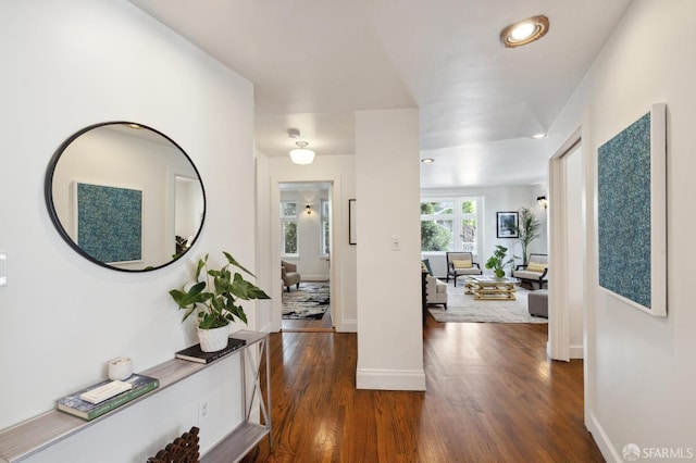 corridor featuring dark wood-type flooring, recessed lighting, and baseboards